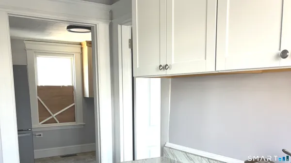 a room with a refrigerator and mirror