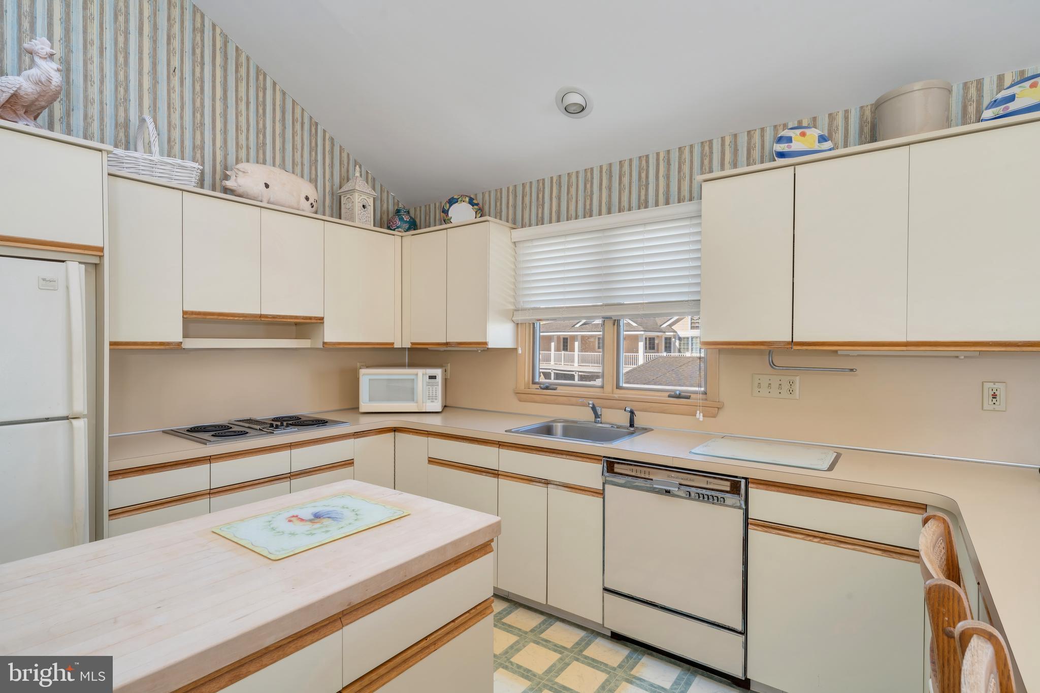 177 74th Street Avalon, NJ 08202 - Photo 45 of 54 a kitchen with kitchen island white cabinets and white appliances