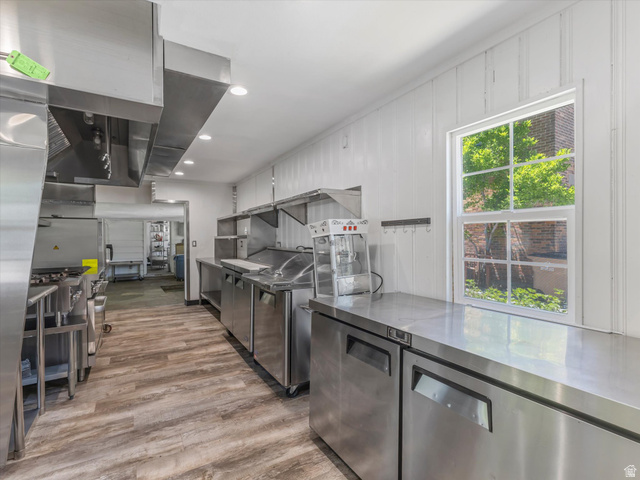 12825 South Fort Street Draper, UT 84020 - Photo 43 of 52 Commercial kitchen featuring extensive stainless steel countertops, professional-grade ventilation hoods, and wood-finish flooring