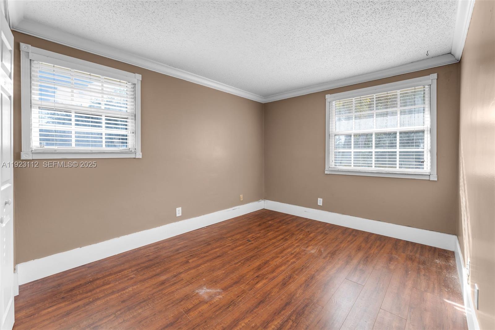 15016 Southwest 139th Avenue Miami, FL 33186 - Photo 13 of 24 a view of empty room with wooden floor and fan