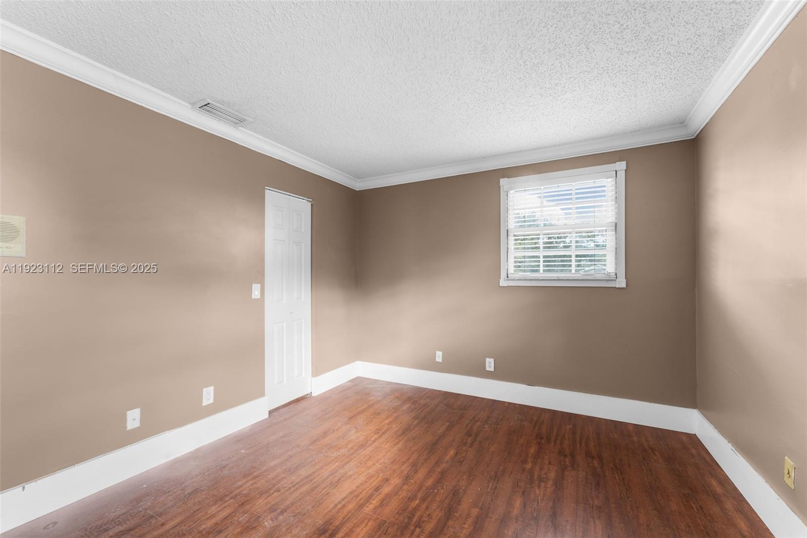 15016 Southwest 139th Avenue Miami, FL 33186 - Photo 16 of 24 wooden floor in an empty room with a window