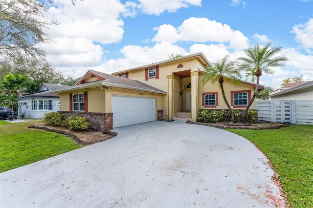 a view of a white house with a yard and potted plants
