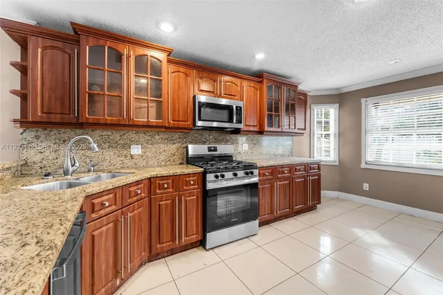 a kitchen with stainless steel appliances granite countertop a refrigerator and a sink