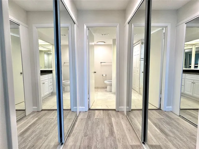 a view of a bathroom with a glass door and a wooden floor