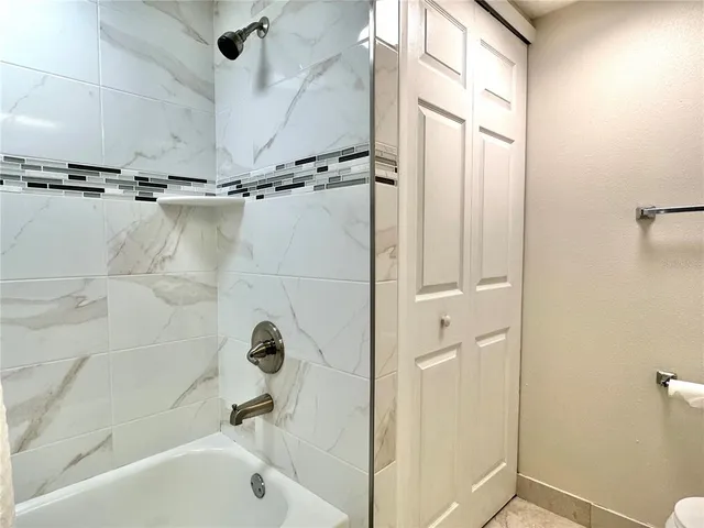 a bathroom with a tub a mirror and a shower