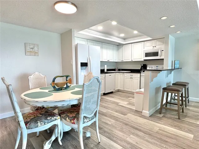 a kitchen with stainless steel appliances granite countertop a stove top oven a sink dishwasher with a dining table and chairs