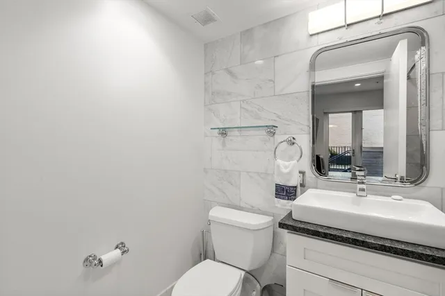 a bathroom with a sink toilet and mirror