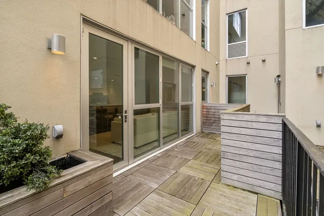 a view of a balcony with wooden floor and potted plants