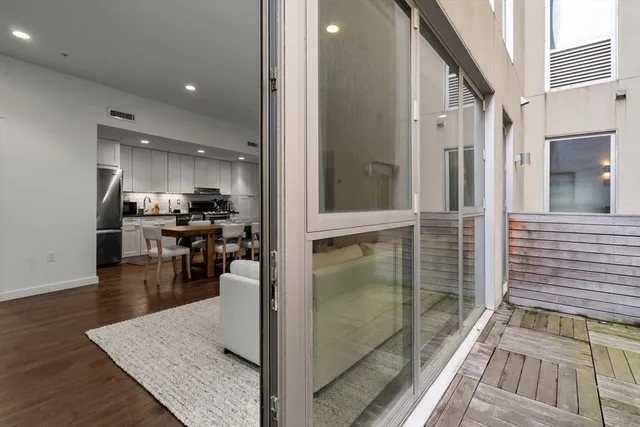 a kitchen with stainless steel appliances kitchen island granite countertop a refrigerator a stove and white cabinets with wooden floor