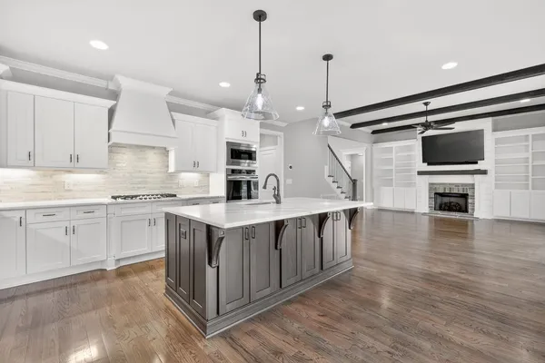 a kitchen with kitchen island granite countertop a sink appliances and cabinets
