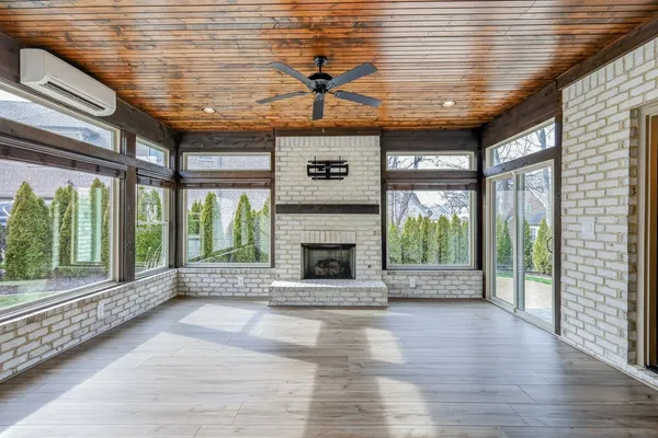 a view of an empty room with wooden floor and a fireplace