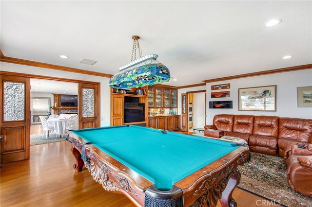 a patio with a table and chairs plants and large trees