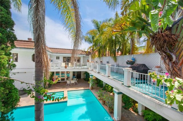 a view of a house with large trees and plants