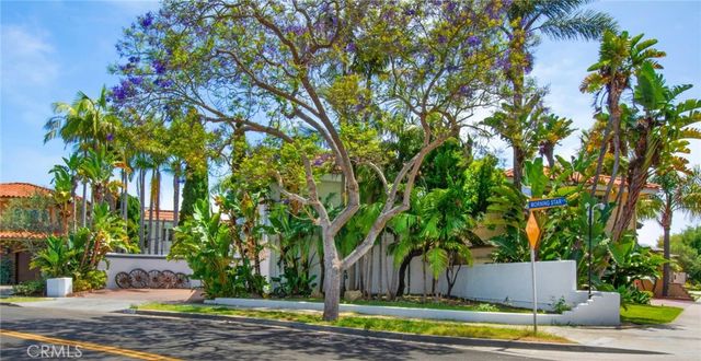 a white house that has a tree in front of it