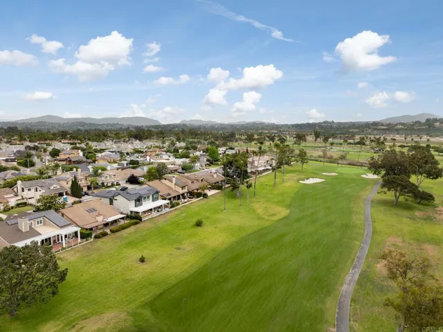 an aerial view of residential houses with outdoor space and ocean view
