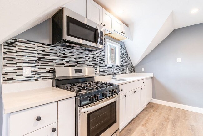 a kitchen with stainless steel appliances white cabinets and stove