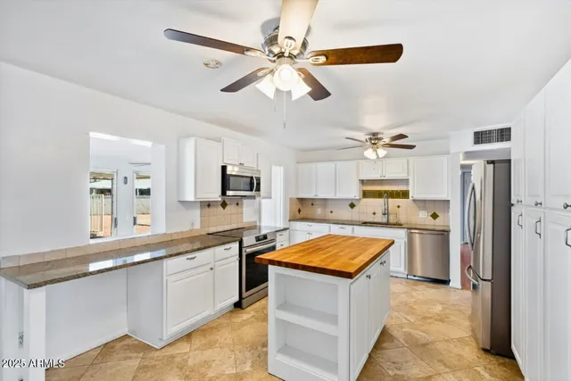 a view of a kitchen with a sink and refrigerator