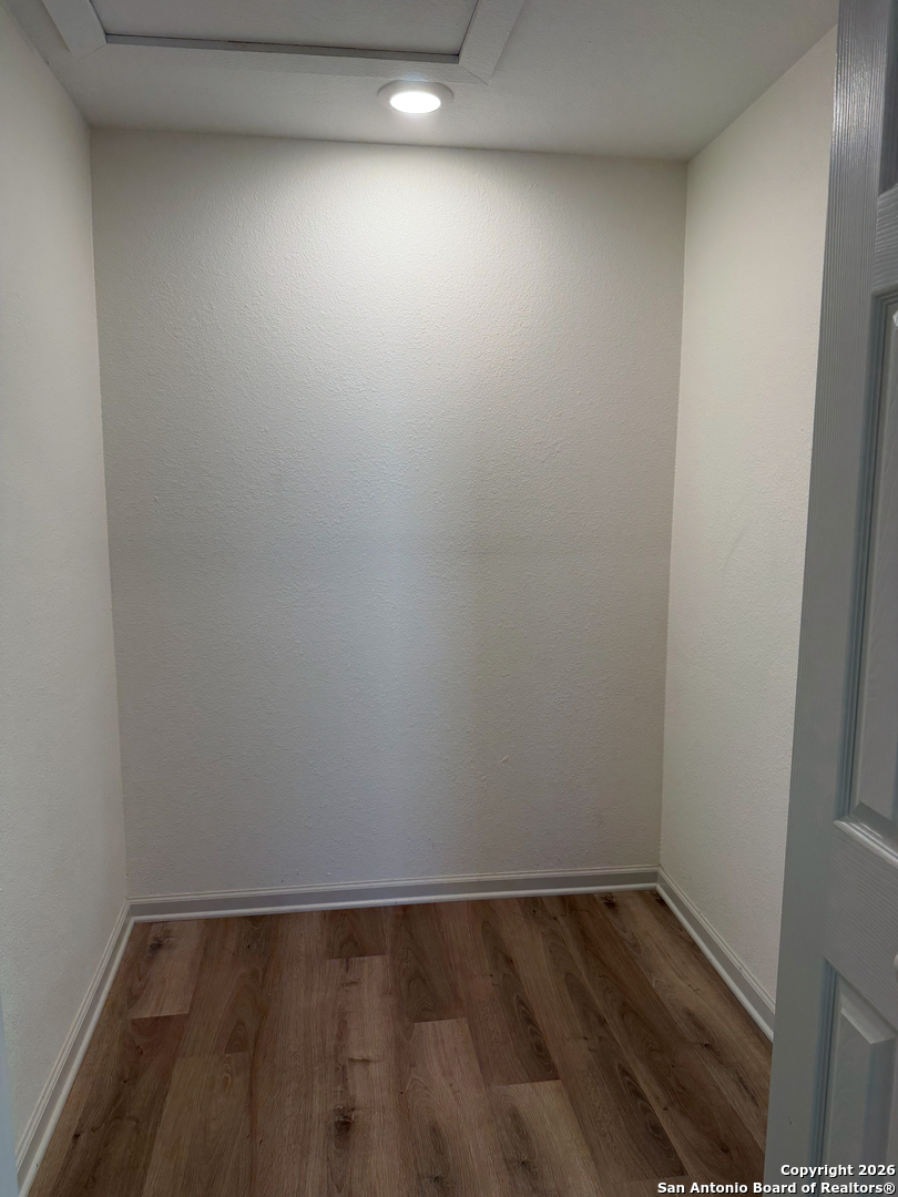 409 Coughran Street Pleasanton, TX 78064 - Photo 11 of 16 a view of an empty room with wooden floor and a window