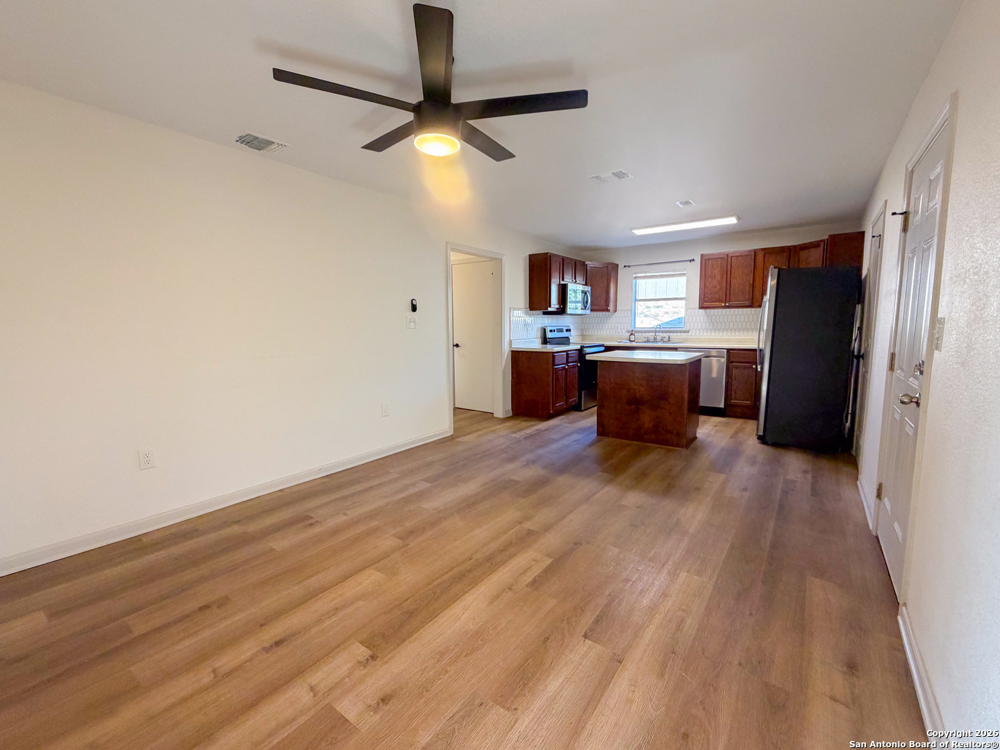 409 Coughran Street Pleasanton, TX 78064 - Photo 3 of 16 a view of a kitchen with a stove cabinets and wooden floor