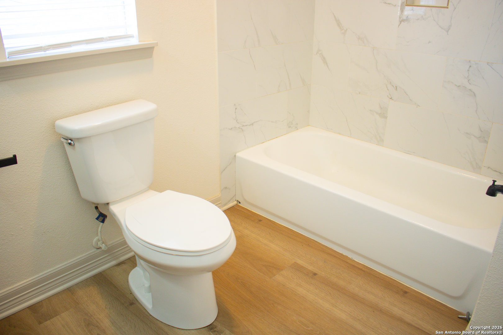 409 Coughran Street Pleasanton, TX 78064 - Photo 7 of 16 a bathroom with a toilet and a tub