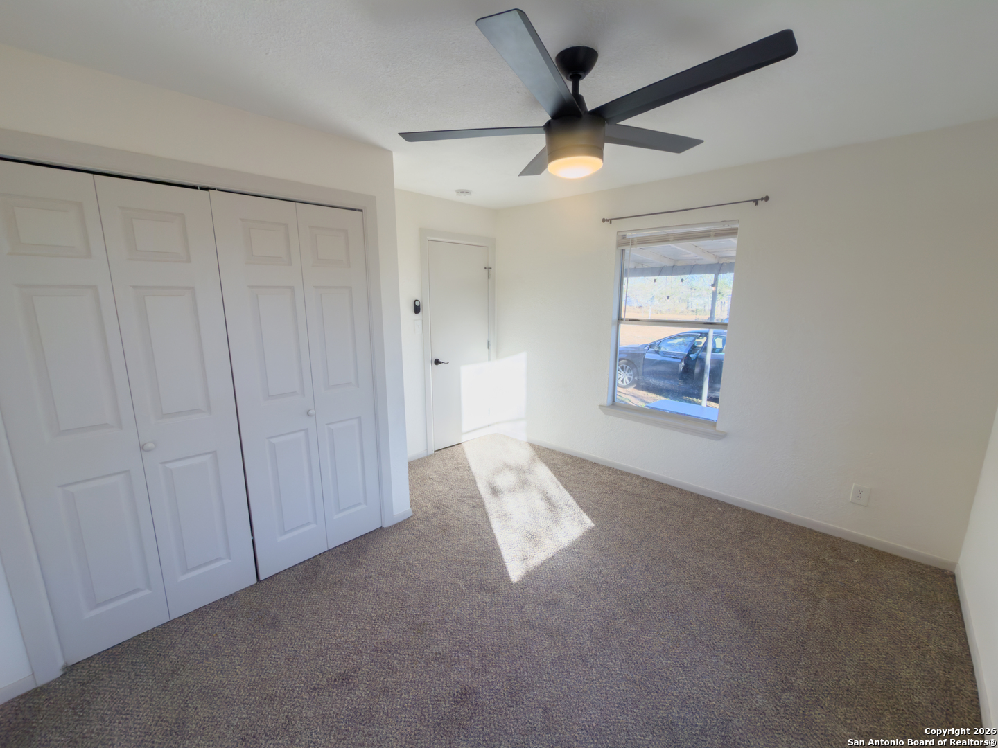 409 Coughran Street Pleasanton, TX 78064 - Photo 10 of 16 an empty room with windows and fan