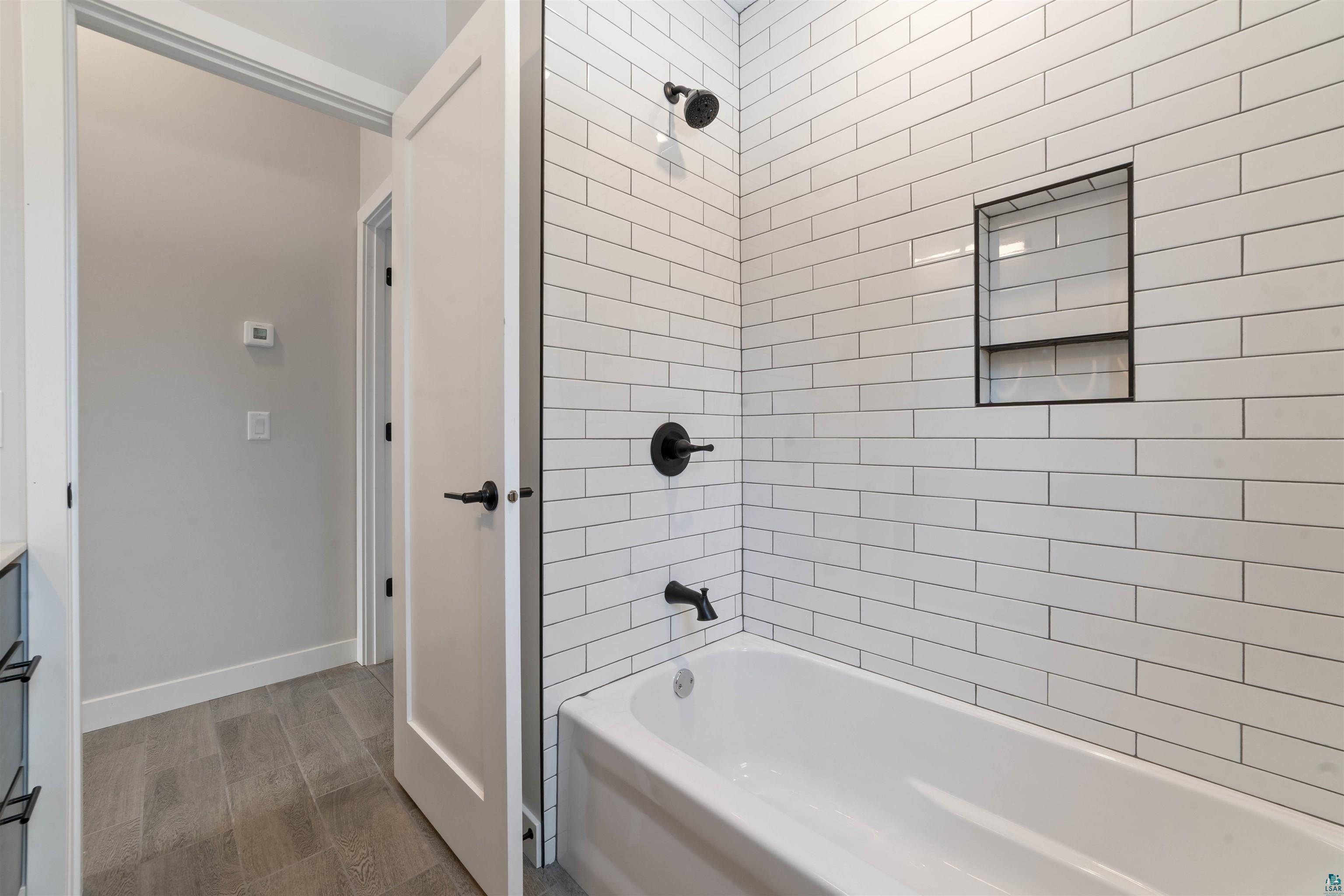 3089 Lavis Road Duluth, MN 55804 - Photo 19 of 30 Full bath featuring baseboards, wood finished floors, and shower / washtub combination