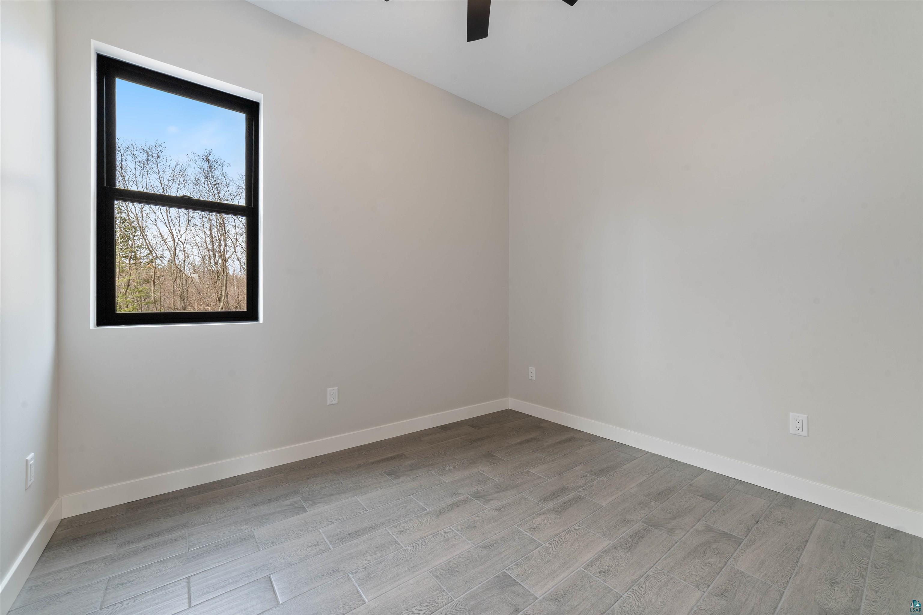 3089 Lavis Road Duluth, MN 55804 - Photo 20 of 30 Unfurnished room featuring baseboards, wood finished floors, and a ceiling fan