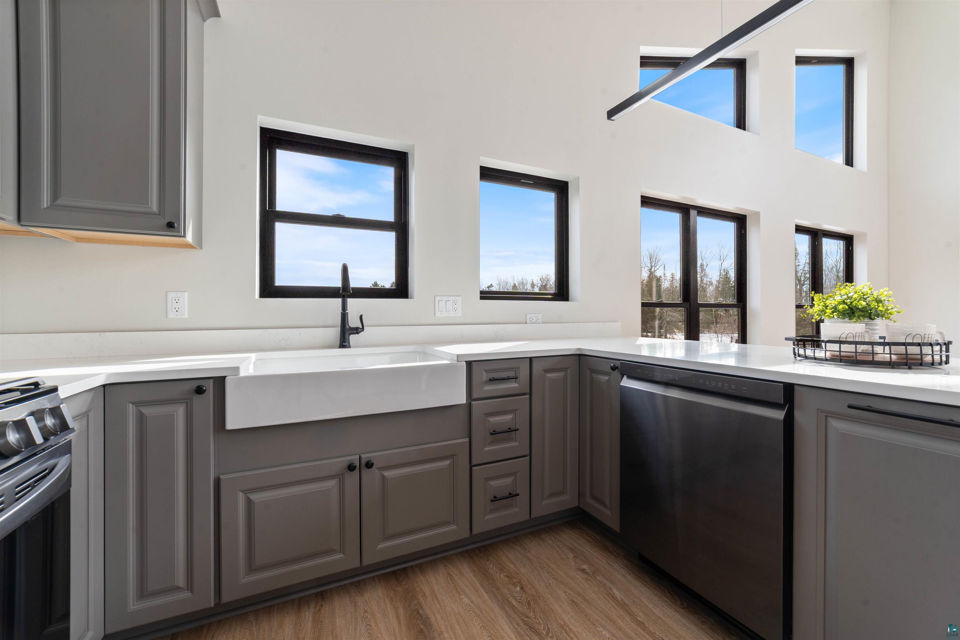 3089 Lavis Road Duluth, MN 55804 - Photo 5 of 30 Kitchen with black stove, a sink, dark wood-style floors, gray cabinets, and stainless steel dishwasher
