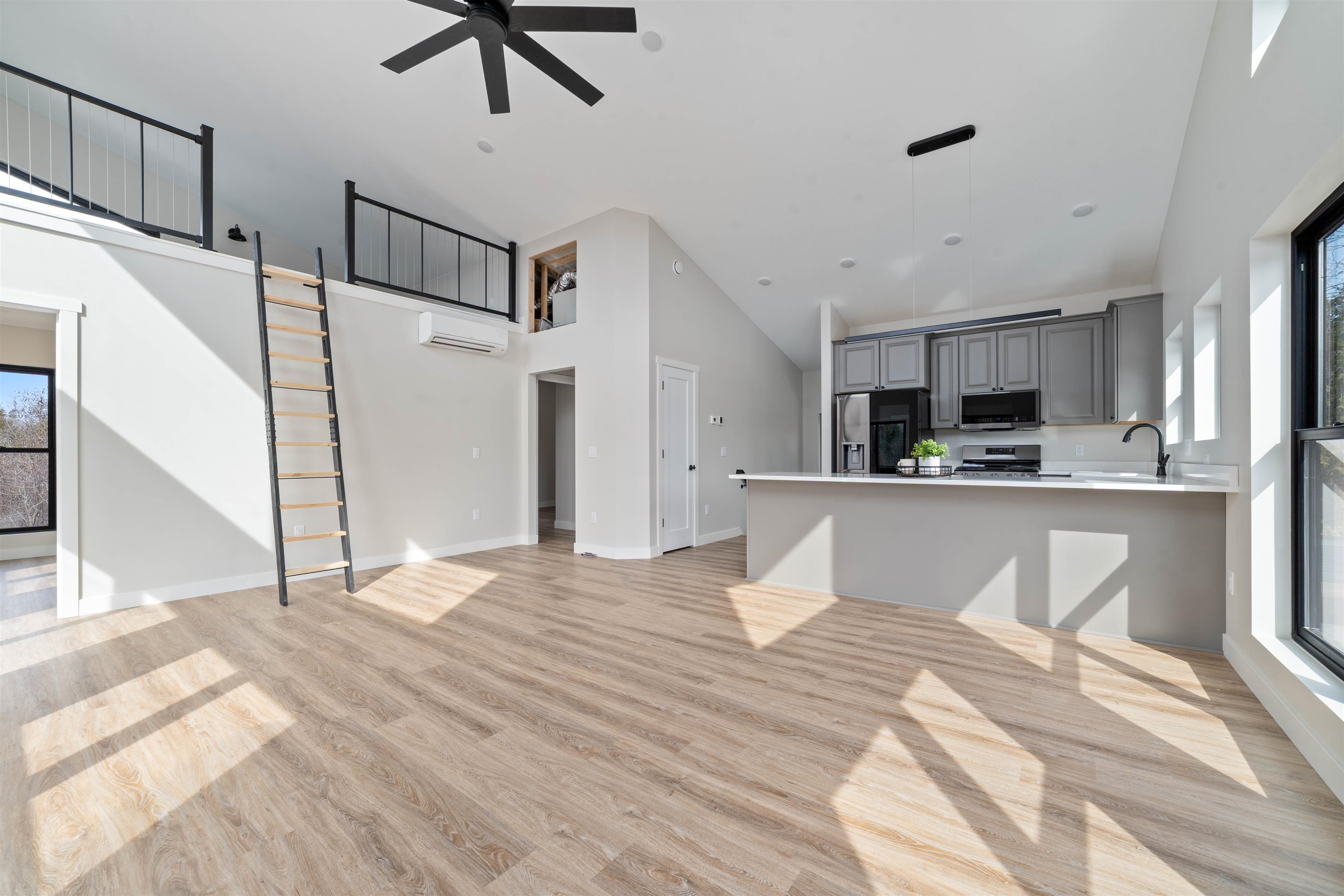 3089 Lavis Road Duluth, MN 55804 - Photo 8 of 30 Unfurnished living room featuring high vaulted ceiling, baseboards, stairs, ceiling fan, and light wood-style floors