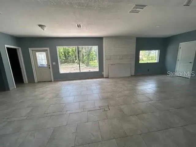 a view of an empty room with glass door and glass door