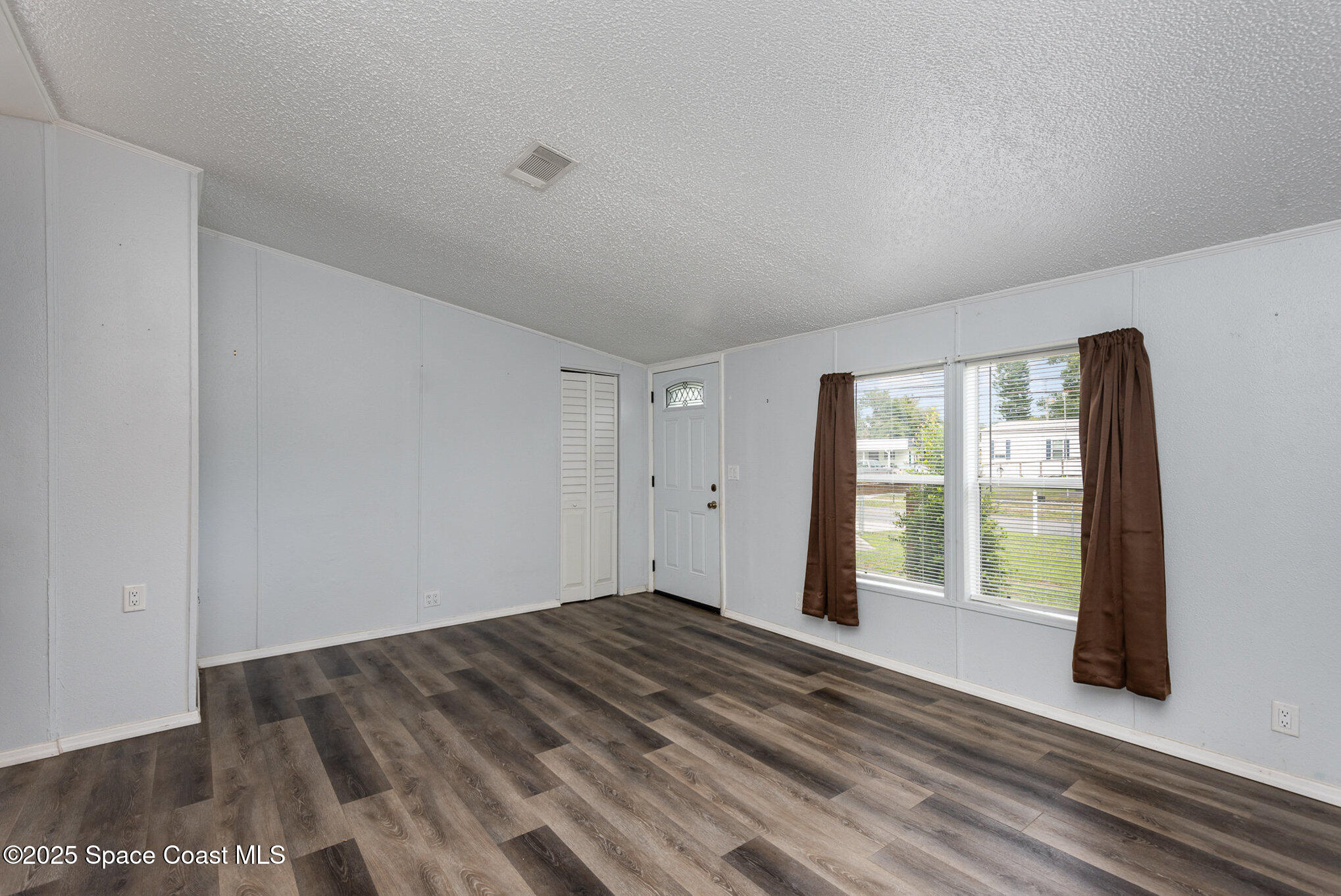 3115 Brockett Road Mims, FL 32754 - Photo 3 of 15 a view of an empty room with wooden floor and a window