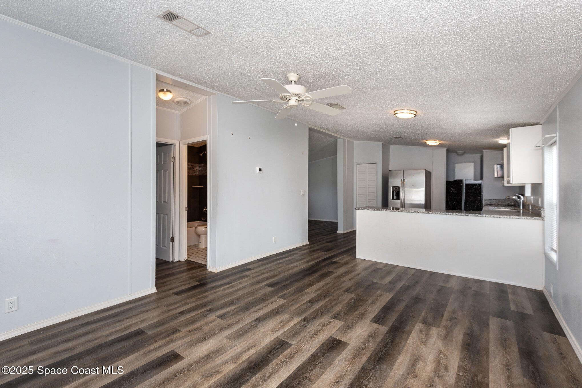 3115 Brockett Road Mims, FL 32754 - Photo 5 of 15 a view of a kitchen with wooden floor and a ceiling fan