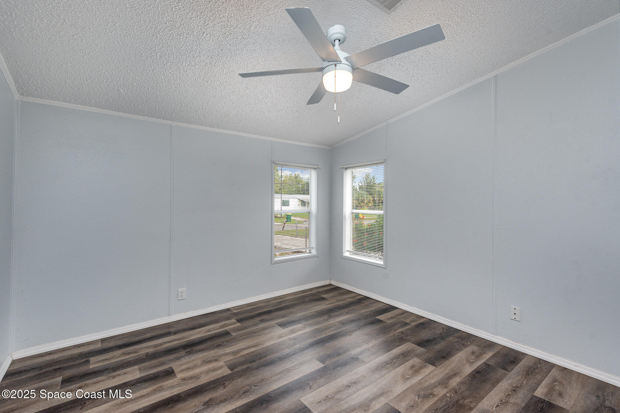 3115 Brockett Road Mims, FL 32754 - Photo 9 of 15 an empty room with wooden floor fan and windows