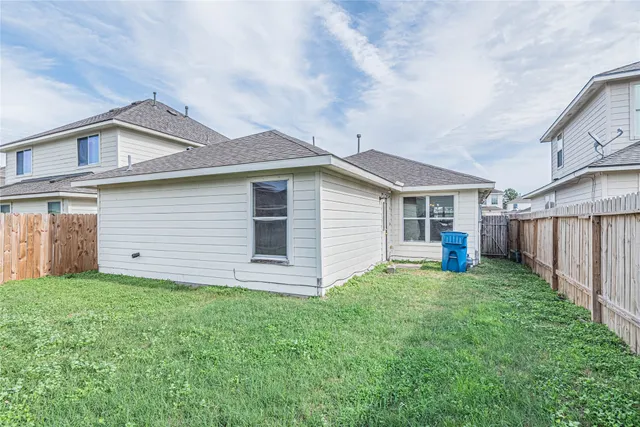 a view of a house with a yard and fence