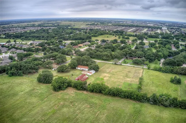 an aerial view of residential houses with outdoor space and trees