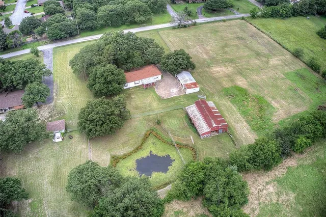 an aerial view of residential houses with outdoor space and street view