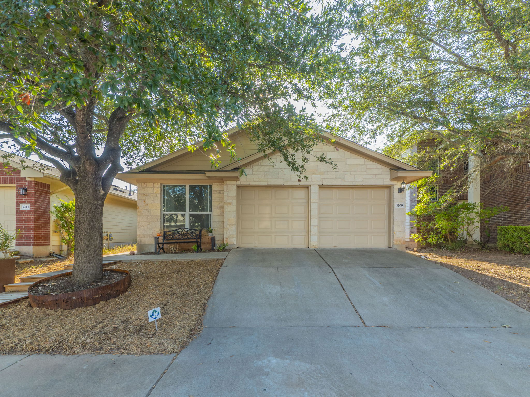 View of front of property featuring driveway, a garage, and stone siding