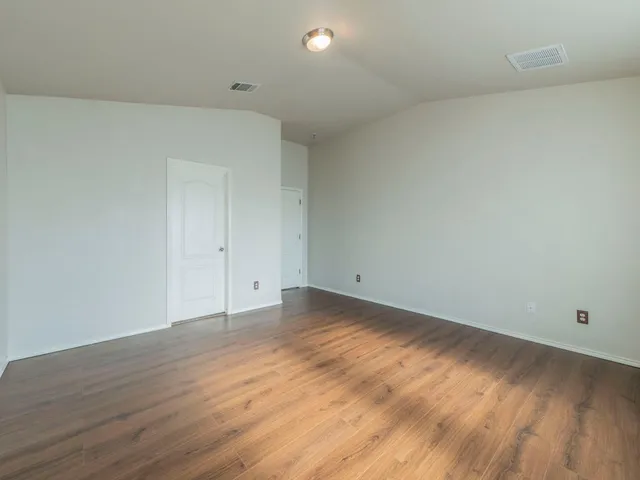 a view of a room with wooden floor