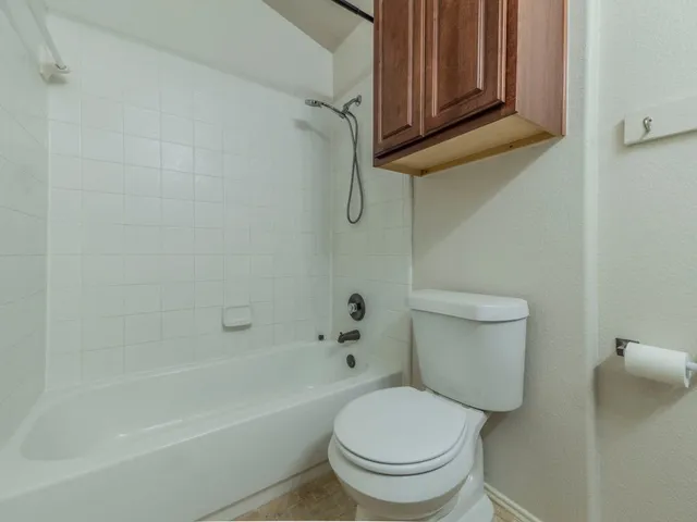 a white toilet sitting next to a bath tub