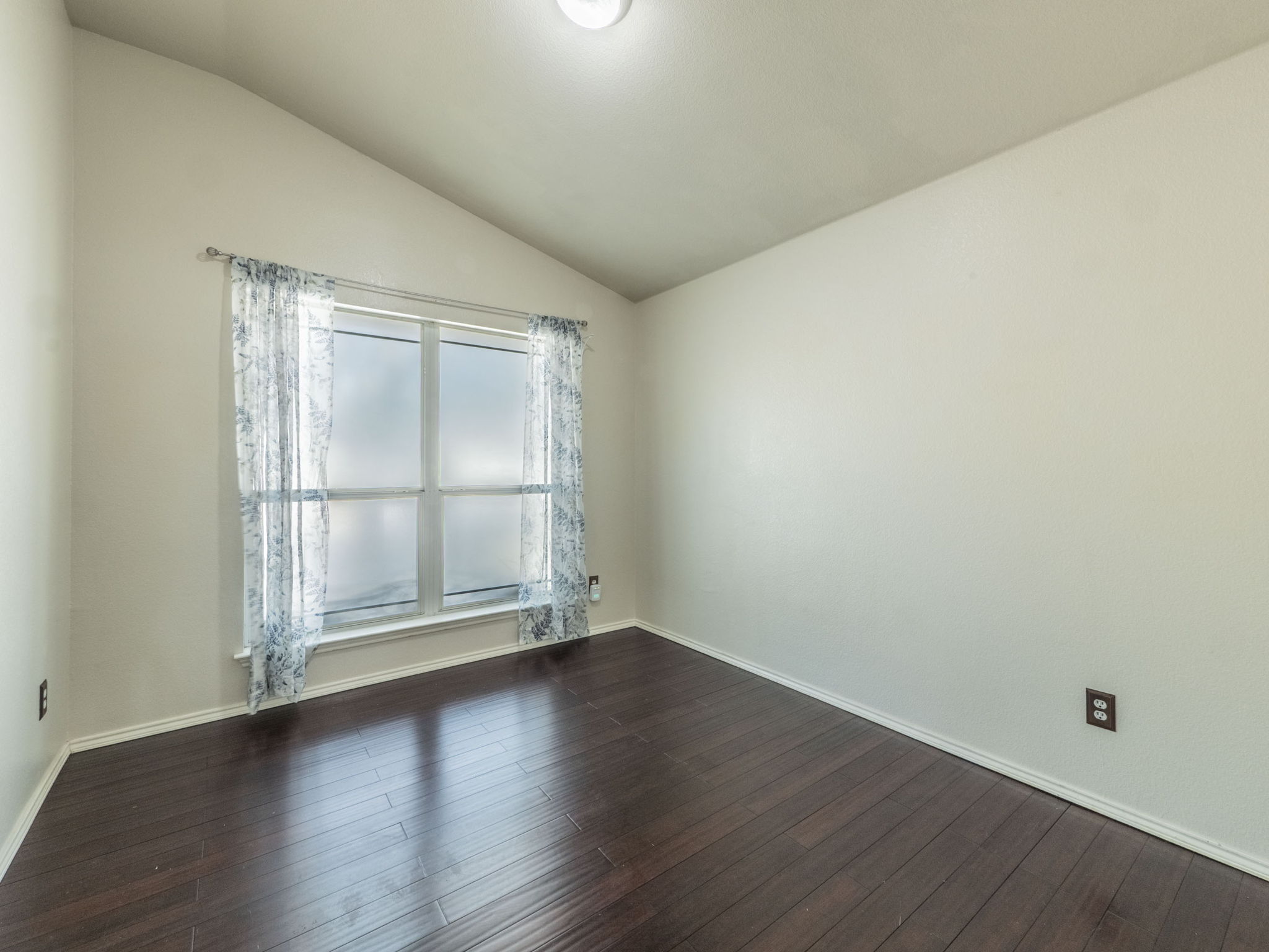 3209 Wickham Lane Austin, TX 78725 - Photo 18 of 26 Spare room with lofted ceiling and dark wood finished floors