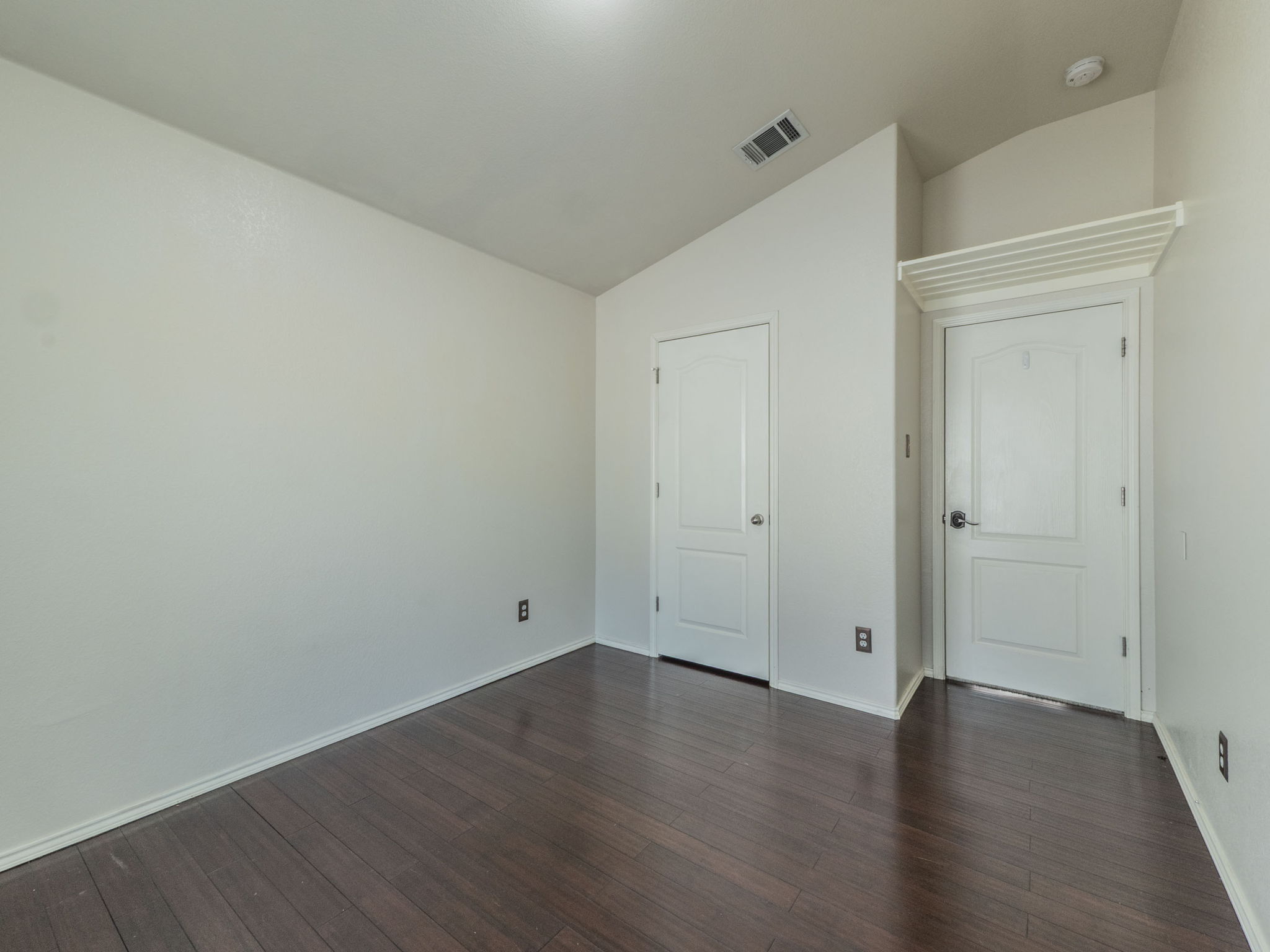 3209 Wickham Lane Austin, TX 78725 - Photo 19 of 26 Unfurnished bedroom featuring lofted ceiling and dark wood finished floors