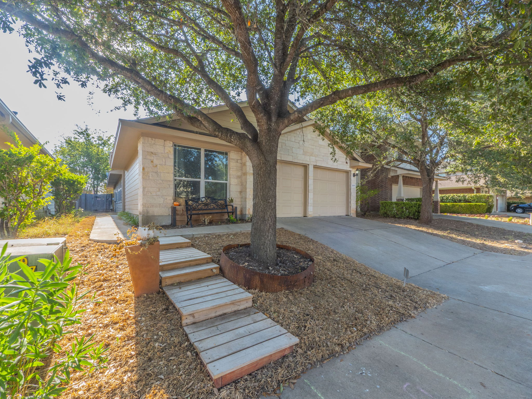3209 Wickham Lane Austin, TX 78725 - Photo 2 of 26 View of front facade with concrete driveway, stone siding, and an attached garage
