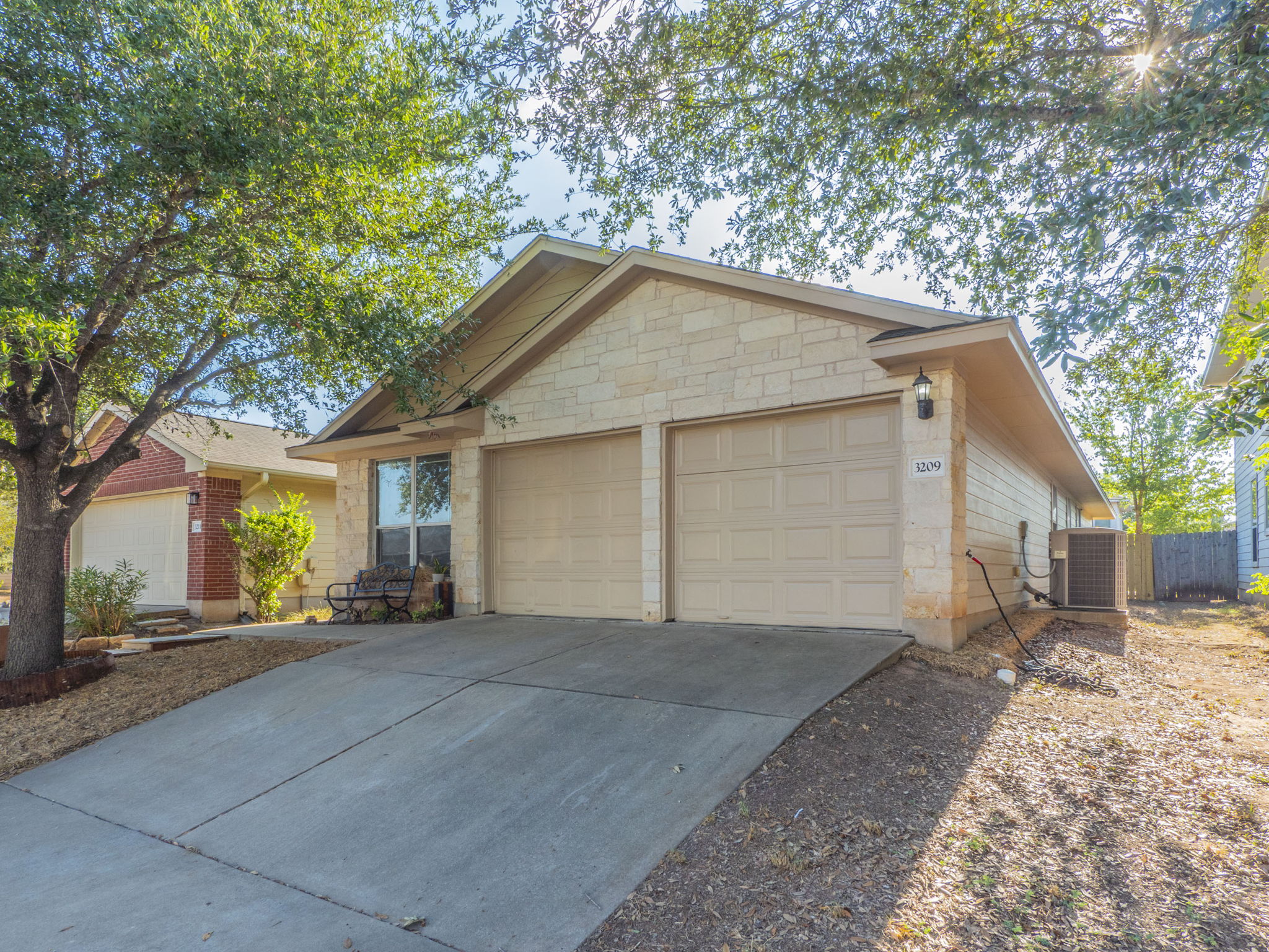 3209 Wickham Lane Austin, TX 78725 - Photo 22 of 26 Ranch-style home with concrete driveway, stone siding, and a garage