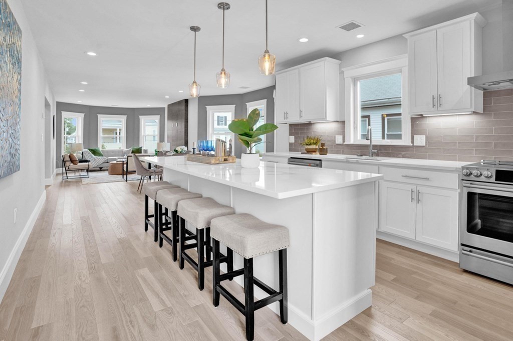 63 Kenmere Road, Unit 2 Medford, MA 02155 - Photo 1 of 42 a open kitchen with stainless steel appliances granite countertop a stove a sink dishwasher a microwave oven a stove with white cabinets and wooden floor