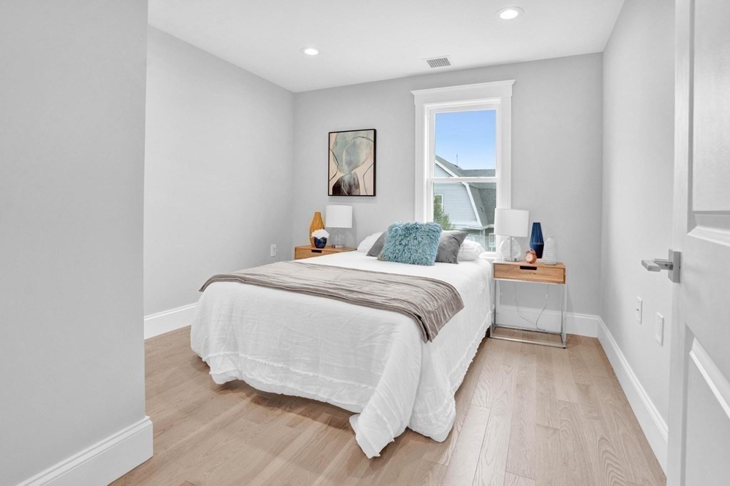 63 Kenmere Road, Unit 2 Medford, MA 02155 - Photo 25 of 42 a bedroom with a bed and painting on the wall
