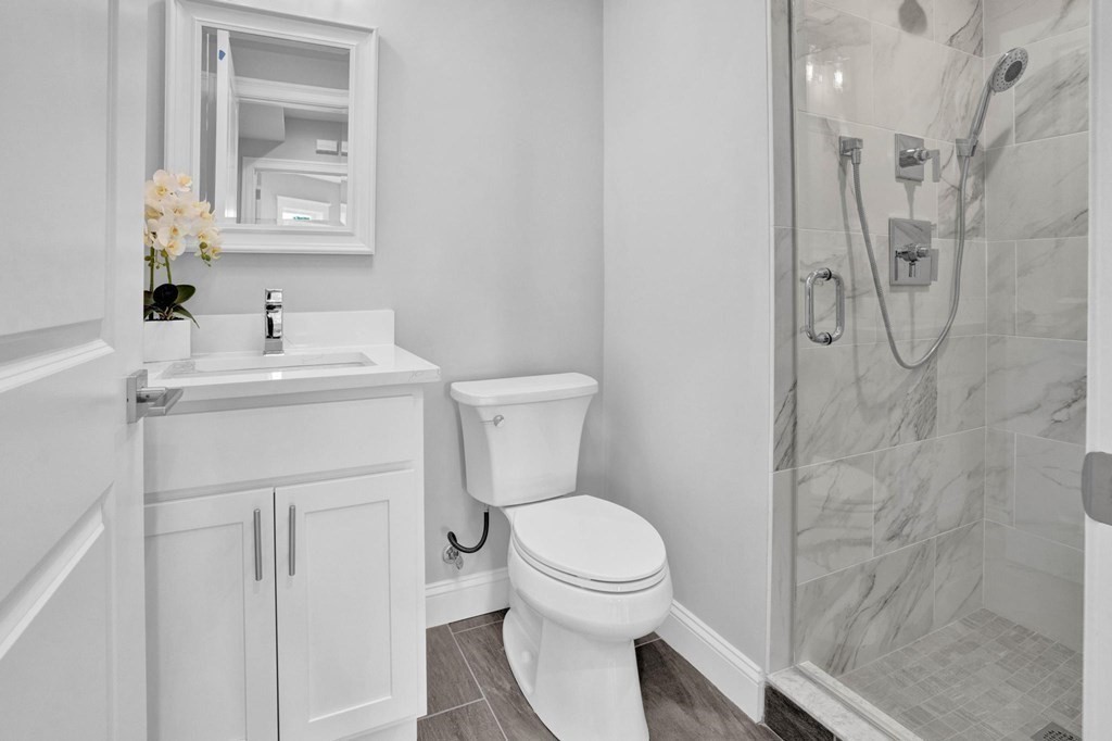 63 Kenmere Road, Unit 2 Medford, MA 02155 - Photo 31 of 42 a bathroom with a toilet sink vanity and mirror