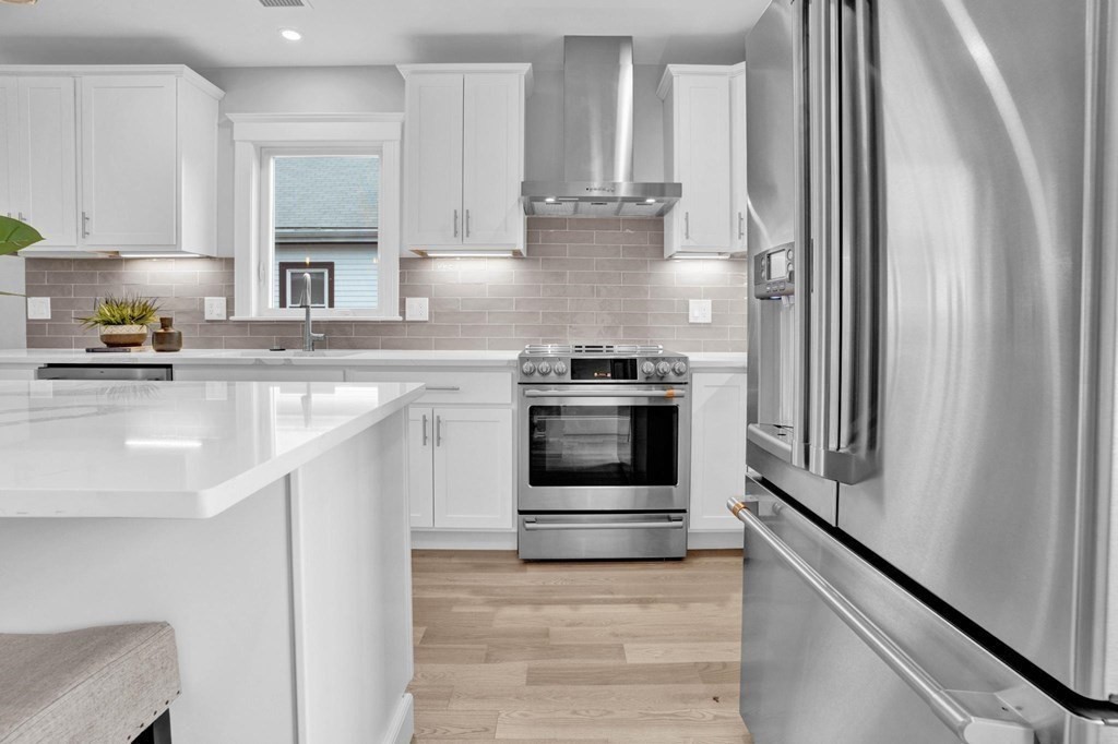 63 Kenmere Road, Unit 2 Medford, MA 02155 - Photo 4 of 42 a kitchen with stainless steel appliances granite countertop a stove and a refrigerator