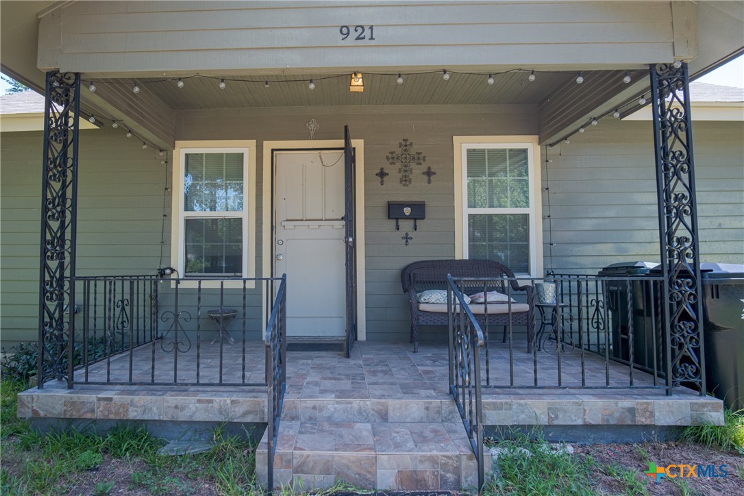 a view of a patio with table and chairs potted plants with wooden floor and fence