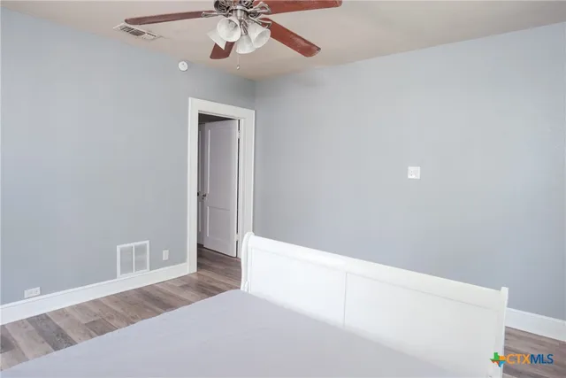 a view of an empty room with a chandelier fan