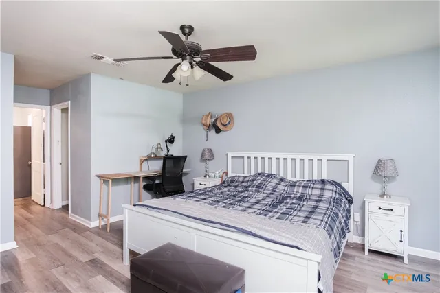 a bedroom with a large bed and a chandelier
